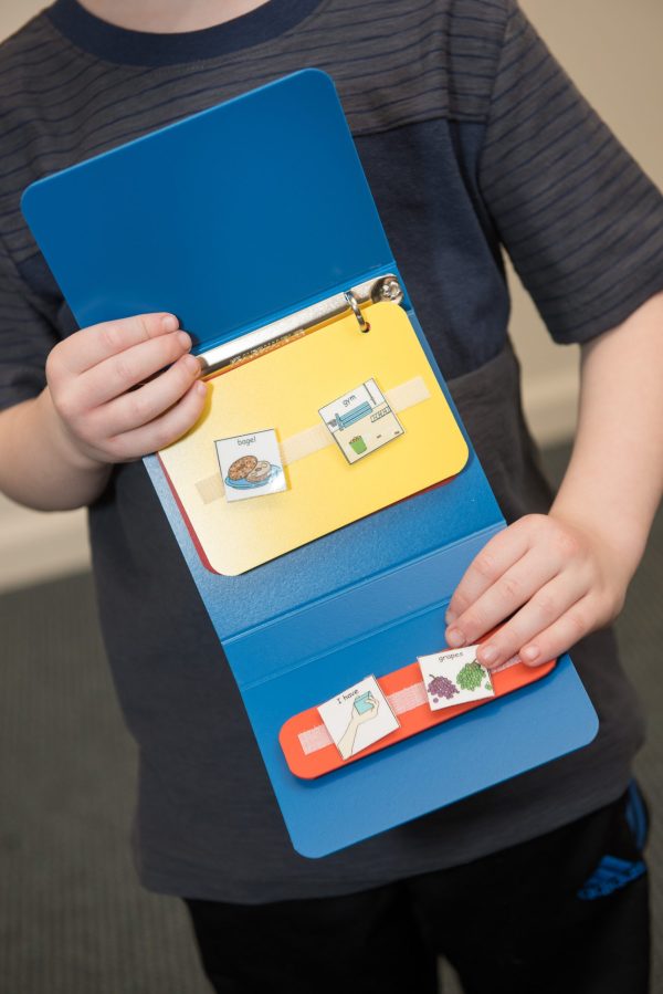 Child holding communication binder.