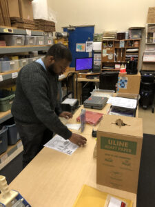 Young man filling a PECS product order in a warehouse