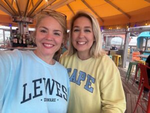 Two women are standing together smiling.