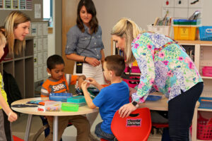 A preschool classroom with teacher, support staff and students