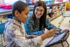 Teacher and student using tablet.